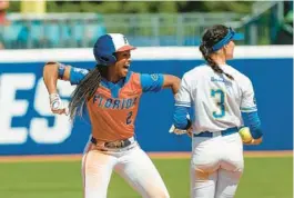  ?? ALONZO ADAMS/AP ?? Florida’s Cheyenne Lindsey celebrates after reaching second base before UCLA infielder Briana Perez could make a tag during the fifth inning of their Women’s College World Series game on Sunday.