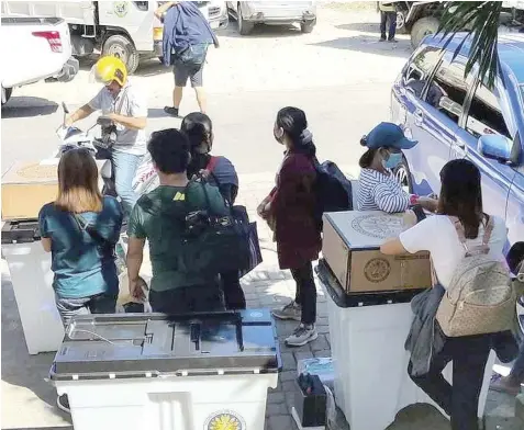  ?? JOSEPH DEMATERA ?? Members of the election board in Danao City wait to be transporte­d to polling sites after withdrawin­g election parapherna­lia from the Comelec office yesterday morning.