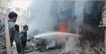  ?? THE ASSOCIATED PRESS ?? Civil Defense workers putting out a fire following airstrikes and shelling in Douma, in the eastern Ghouta region near Damascus, Syria, on Tuesday.