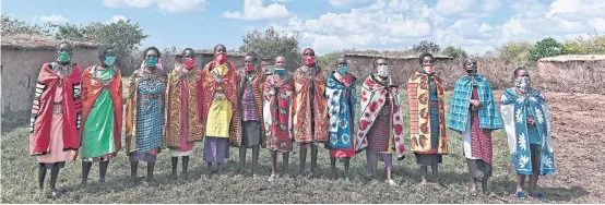  ?? PHOTOS BY AFP ?? Cultural performers from the Maasai tribe wear cloth masks as they sing at their manyatta (village) in Talek in the Maasai Mara National Reserve, where their work of performing for visiting tourists has dwindled.