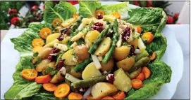  ?? ?? A salad of asparagus and potatoes with kumquats is served on a bed of romaine.