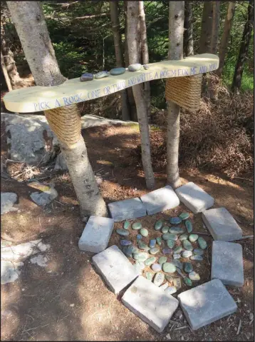  ??  ?? At the Manuel’s River walking trail there’s a ‘Poem Place’. The wooden shelf/sign on the trees says, “Pick a rock, one or two, and write a poem for me and you”. Many of the small, smooth stones bear little sayings, names and pieces of poems.