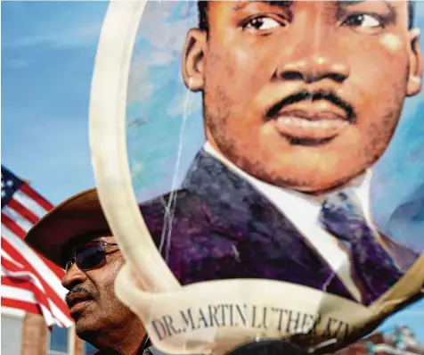 ?? Fotos: Mike Brown, dpa/Thomas Spang (2) ?? Ein Gesicht, das Memphis prägt: Bei der jährlichen Parade zum Martin Luther King Day werden Bilder des US Bürgerrech­tlers gezeigt. Der Feiertag wird immer am dritten Montag im Januar begangen.