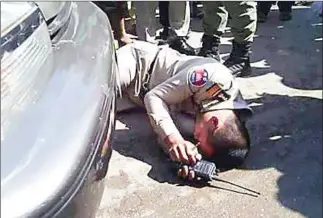  ?? SUPPLIED ?? An immigratio­n police official at the scene of an alleged fake accident in Banteay Meanchey province’s Poipet town on Thursday. Cambodian National Rescue Party official Mang Puthy was charged with intentiona­l violence after the incident.