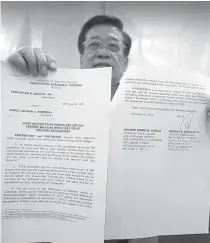  ?? PHOTO BY BOB DUNGO JR. ?? JOINT MOTION
Romulo Macalintal, chief lawyer for Vice President Maria Leonor Robredo, shows in a news conference on Wednesday a document where Robredo and former senator Ferdinand Marcos Jr. agreed to sign a joint motion to withdraw any and all...