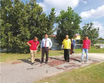  ??  ?? Ting (second right) being accompanie­d by Michael (second left) and JKR officers to inspect the running track at SMK Lutong yesterday.