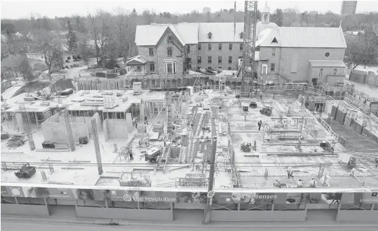  ?? JULIE OLIVER/OTTAWA CITIZEN ?? A trio of condo buildings that will front QWest rise out of the basement as constructi­on continues. Behind is the abbey, which will be renovated and converted to retail space.