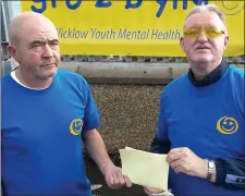  ??  ?? Peter O’Reilly accepting a cheque for €300 from Charlie Burke, Chairperso­n of Wicklow Mental Health Associatio­n.