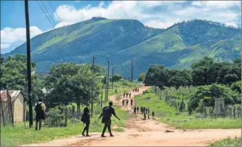  ??  ?? Passport to possibilit­y: Swazi children rent rooms and attend school in South African villages (above) in the Jeppes Reef area near the border. Taxi bakkies (below left) run between the illegal border crossing and a village in Jeppes Reef. Members of...