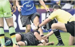  ??  ?? High risks: a rugby player is treated for a head injury