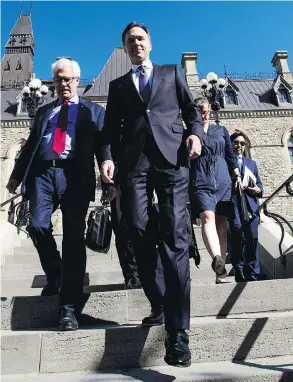  ?? SEAN KILPATRICK / THE CANADIAN PRESS ?? Natural Resources Minister James Carr and Finance Minister Bill Morneau leave a cabinet meeting to announce Ottawa is buying the Trans Mountain pipeline.