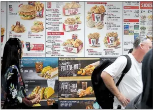  ?? AP/BEBETO MATTHEWS ?? Diners check a menu recently at a KFC in New York that displays calorie counts of menu items. The Trump administra­tion is proceeding with requiremen­ts that restaurant chains, convenienc­e stores, pizza delivery chains and movie theaters post calorie...