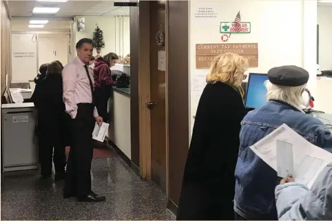  ?? (Daniel Bases/Reuters) ?? CHARLES STROME (left), New Rochelle’s city manager, waits in line at New Rochelle City Hall to prepay the assessed portion of his 2018 state and local tax bill last Thursday. Municipal coffers fattened up as taxpayers paid taxes with the hopes of...