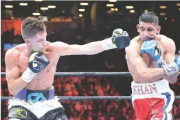  ?? (AP) ?? Amir Khan (right) of England and Chris Algieri of the US, a one-time Manny Pacquiao victim, trade power shots in the fifth round of their fight on Friday in New York. Khan won on points.