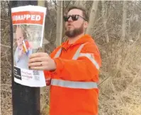  ?? (Semyon Dozhik) ?? A TORONTO municipal worker removes a missing persons poster of hostage Kfir Bibas.