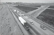  ?? Patrick T. Fallon/AFP via Getty Images/TNS ?? An aerial picture taken on Aug. 26, 2021, shows trucks, cars, and other vehicles sitting in traffic due to road constructi­on on Interstate 5 as they transit through the Tejon Pass from the Grapevine in Kern County, California.