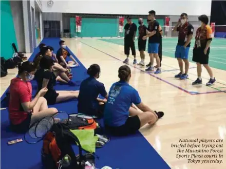  ??  ?? National players are briefed before trying out the Musashino Forest Sports Plaza courts in Tokyo yesterday.