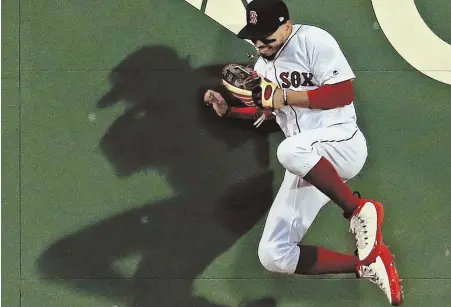  ?? STAFF PHOTO BY MATT STONE ?? BEYOND A SHADOW OF A DOUBT: Mookie Betts slams into the center field wall making a catch on the Rangers' Elvis Andrus during the fifth inning of the Red Sox' 5-0 victory last night at Fenway.