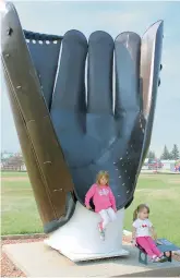  ??  ?? Above: Emily (left) and Alexa at Canada’s largest baseball glove in Heisler, Alta. Far left: Alexa and Gramma Linda on a wagon seat with the driver.