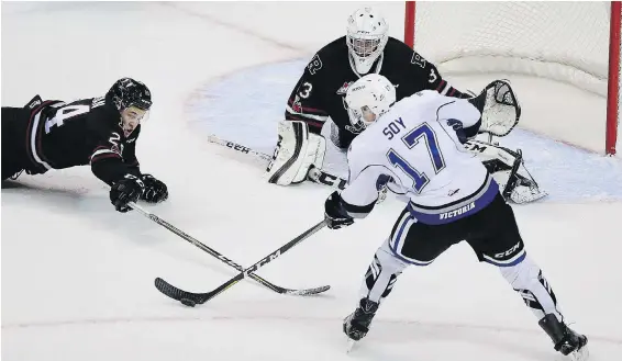  ??  ?? The Royals’ Tyler Soy takes a shot on Red Deer Rebels’ goaltender Riley Lamb as Jack Flaman, left, dives to try and block the shot during their WHL game at Save-On-Foods Memorial Centre on Tuesday.
