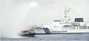  ??  ?? This handout picture shows a Japan Coast Guard vessel firing water cannons to a North Korean fishing boat to expel from Japan waters, in Japan’s exclusive economic zone at Sea of Japan. — AFP photo