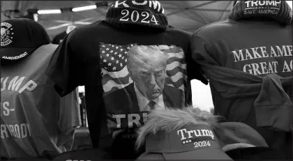  ?? CHARLIE NEIBERGALL / ASSOCIATED PRESS ?? Shirts and hats are seen at a vendor’s stand Wednesday before a caucus rally in Coralville, Iowa.