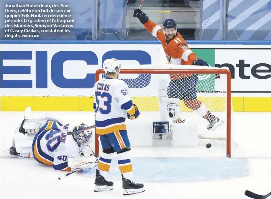  ?? PHOTO AFP ?? Jonathan Huberdeau, des Panthers, célèbre un but de son coéquipier Erik Haula en deuxième période. Le gardien et l’attaquant des Islanders, Semyon Varlamov et Casey Cizikas, constatent les dégâts.