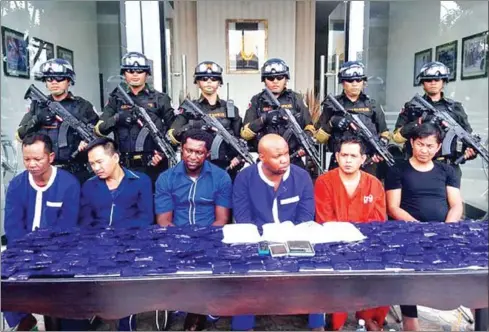  ?? SUPPLIED ?? Prisoners pose for a photo with packages of drugs and members of the Gendamerie in 2016 in Phnom Penh.