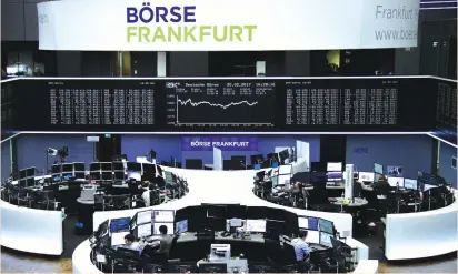  ?? (Reuters) ?? TRADERS WORK at their desks on the floor of the Frankfurt Stock Exchange yesterday. The pan-European STOXX 600 index edged up 0.1% to just below a 14-month high touched last week.