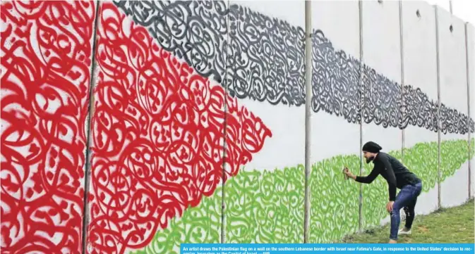  ??  ?? An artist draws the Palestinia­n flag on a wall on the southern Lebanese border with Israel near Fatima’s Gate, in response to the United States’ decision to recognize Jerusalem as the Capital of Israel.—AFP