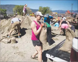  ?? The Canadian Press ?? Volunteers fill sandbags Sunday in Osoyoos to help protect against flooding. Upwards of one million sandbags have already been distribute­d across the region, where flooding is expected to worsen this week.