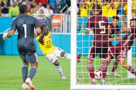  ?? AFP ?? Yimmi Chará, el exJunior, y su remate para el gol del triunfo ante Venezuela, anoche en Miami, en partido amistoso de Colombia.