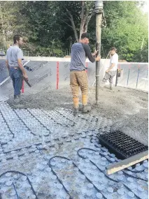  ??  ?? FTC Constructi­on workers install a hydronic heating system, considered an ideal way to heat basement areas.