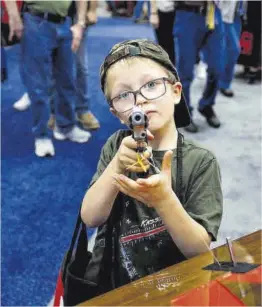  ?? Evelyn Hockstein / Reuters ?? Un nen empunya una arma en un acte de l’Associació del Rifle.