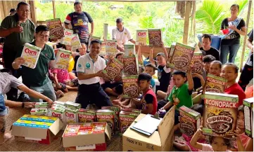  ??  ?? Wan (kneeling front, second left) and Dr Yii (left) join the children of Kampung Muk Ayun in a group photo.