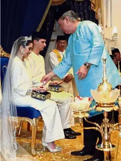  ??  ?? Royal blessing: Sultan Ibrahim blessing Tunku Aminah and Dennis Muhammad during the ‘bersanding’ ceremony at Istana Besar in Johor Baru.