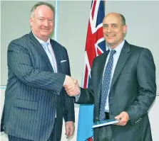  ?? Photo: Office of the Director of Public Prosecutio­ns ?? Judge James E. Baker (right), receiving a copy of the 2013 Fijian Constituti­on from the Director of Public Prosecutio­ns Christophe­r Pryde.