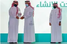  ??  ?? Majed Al-Ghamdi, CEO of retail banking at SNB, receives the award from Majed Al-Hogail, minister of municipal and rural affairs and housing.