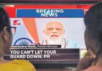  ?? MANJUNATH KIRAN AFP/GETTY IMAGES ?? A family watches Indian Prime Minister Narendra Modi addressing the country. Modi has urged citizens to tighten up their vigilance against the coronaviru­s.