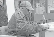  ?? Brooke Keast / Nevada Department of Correction­s via AP ?? Former football star O.J. Simpson signs documents Saturday at the Lovelock Correction­al Center in Lovelock, Nev., ahead of his release early Sunday.