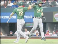  ?? RAY CARLIN — THE ASSOCIATED PRESS ?? The Athletics’ Jed Lowrie, right, is greeted Sunday at the plate by Sean Murphy after hitting a solo home run against Texas.