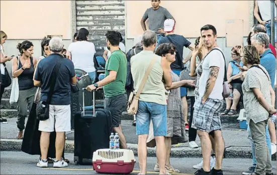  ?? NICOLA MARFISI / AP ?? Vecinos de la zona afectada que han sido evacuados esperaban ayer para recoger algunas pertenenci­as de sus casas