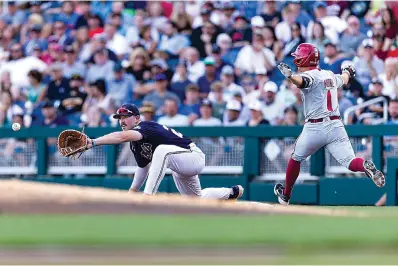  ?? AP Photo/John Peterson ?? ■ Mississipp­i infielder Tim Elko (25) makes a catch for an out against Arkansas infielder Robert Moore (1) in the fourth inning during an NCAA College World Series baseball game Wednesday in Omaha, Neb.