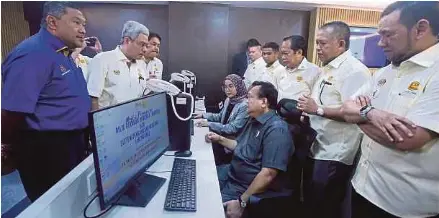 ?? (Foto Hairul Anuar Rahim/bh) ?? Alexander diiringi Ahamd meninjau operasi Bilik Gerakan Bencana selepas merasmikan Bigben dan ebencana di Ibu Pejabat JKR, Kuala Lumpur, semalam.