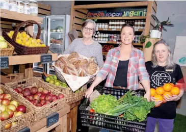  ??  ?? Supplier and committee member Julie Thompson helps to arrange produce at the Baw Baw Food Hub with Kylie Wilson and Janette Clark.