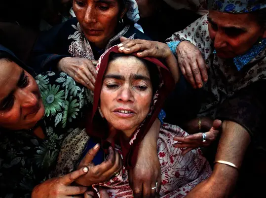  ??  ?? Above: Relatives of Naz Banu, killed during an attack on leading politician Sakina Yatoo, mourn over her body during her funeral in the northern Kashmir town of Mirhama. Saturday, 21 September, 2002.