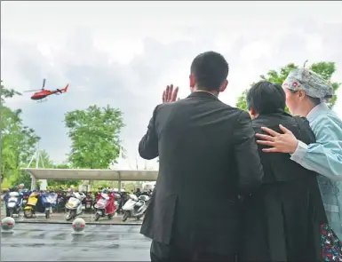  ?? TIAN JIANMING / CHINA DAILY ?? Liu Guoqun’s father, Liu Wanyong (center), and other family members bid farewell to the helicopter carrying the woman’s donated organs from Jiaxing to Hangzhou, Zhejiang province, on Thursday. It was the first step in a transplant relay.