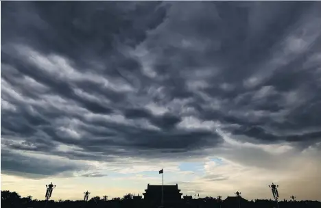  ?? FENG LI/GETTY IMAGES ?? Clouds darken Beijing’s Tiananmen Square following many days of heavy air pollution. Representa­tives from China, Canada and the European Union met Tuesday in Berlin to discuss climate leadership and how to maintain momentum if the U.S. pulls out of the Paris Agreement.