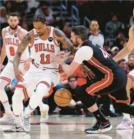  ?? CHRIS SWEDA/CHICAGO TRIBUNE ?? Bulls forward DeMar DeRozan, left, strips the ball away from Heat forward Kevin Love in the first half of a game at the United Center on March 18, 2023.