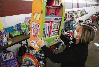  ?? BILL LACKEY/STAFF ?? Salvation Army volunteer Tracy Yates picks out a toy for a child in need during the Salvation Army toy distributi­on Thursday at the Clark County Fairground­s.